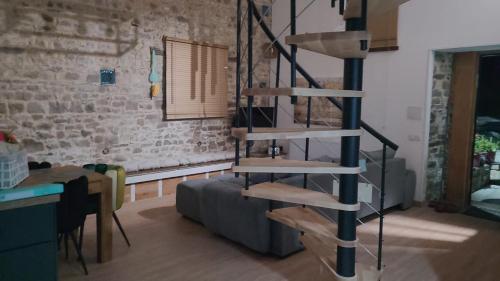 a wooden spiral staircase in a living room with a couch at Holidays-Normandy - Ursula gîte 