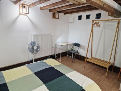 a bedroom with a bed and a desk and a fan at Holidays-Normandy - Ursula gîte 