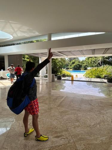 a person with a backpack pointing up at a building at Tambuli Ocean Breeze in Maribago