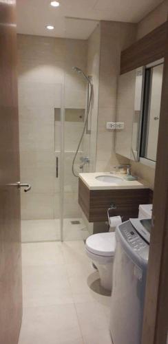 a bathroom with a shower and a toilet and a sink at Tambuli Ocean Breeze in Maribago