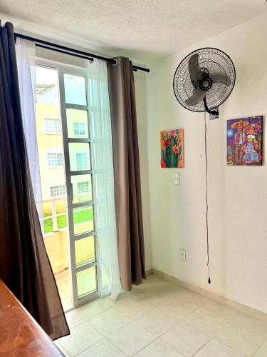 a room with a fan and a window at Depto con PISCINA PUENTE DEL MAR ACAPULCO in Acapulco