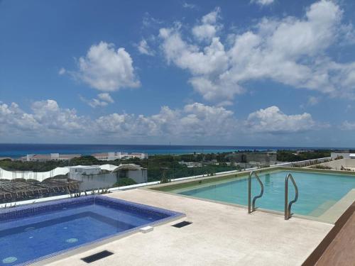 a swimming pool with a view of the ocean at Enjoy yourself in Heaven! in Playa del Carmen