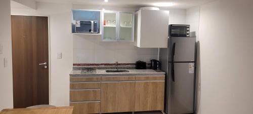 Una cocina con refrigerador y gabinetes de acero inoxidable. en Zafiro Apartments 4 pax, en Buenos Aires