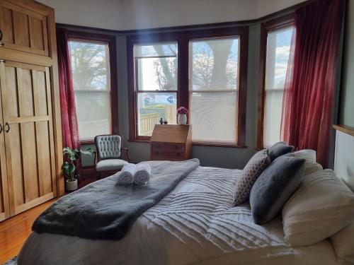 a bedroom with a large bed with towels on it at Villa Charm on Claudelands in Hamilton
