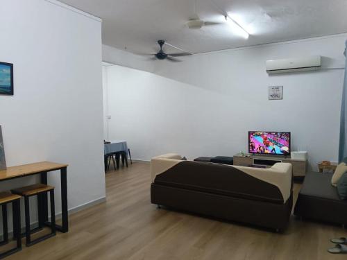 a living room with a couch and a flat screen tv at Faith Homestay at Penampang in Kota Kinabalu