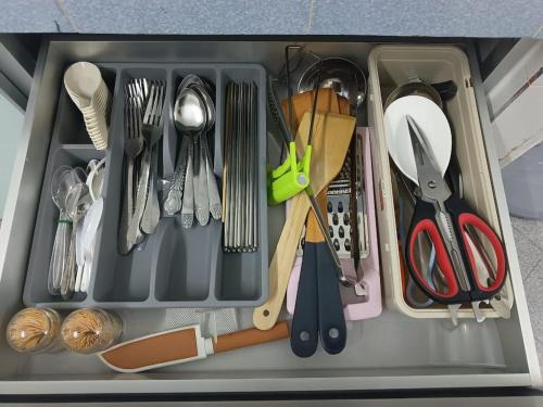 a drawer filled with utensils and other kitchen utensils at Faith Homestay at Penampang in Kota Kinabalu