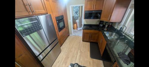a kitchen with wooden cabinets and a stainless steel refrigerator at Spacious West Kelowna Home that is great for family, friends, or business trip! in West Kelowna
