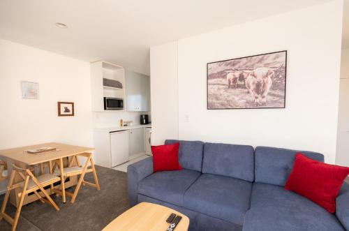 ein Wohnzimmer mit einem blauen Sofa und einem Tisch in der Unterkunft Cozy and Comfortable in Central Christchurch with Hagley Park Views in Christchurch