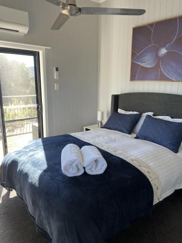 a bedroom with a bed with two towels on it at Back Creek Estate Cottage in Severnlea