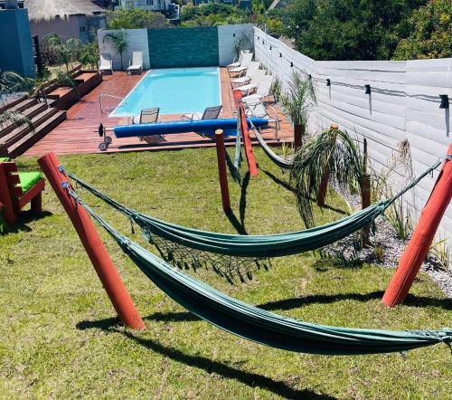 a hammock in a yard next to a pool at Las Totoras PDD in Punta Del Diablo