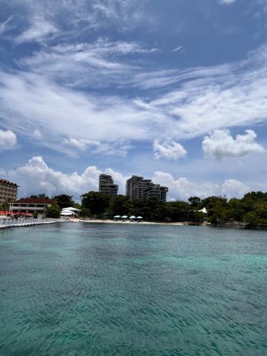 a large body of water with buildings in the background at Tambuli Ocean Breeze in Maribago