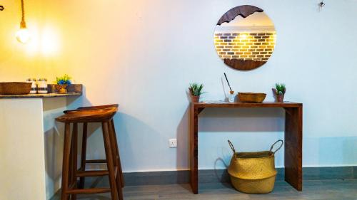 a room with two stools and a table with a basket at The apartments-Bwebajja in Bwebajja