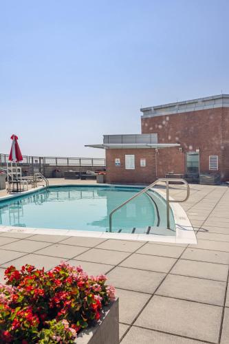 a swimming pool with some flowers in front of a building at DTSS LuxePad 2BED 2BATH Washington DC Balcony Views, Gym, Pool, Free Parking in Silver Spring