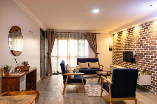 a living room with a blue couch and a brick wall at The apartments-Bwebajja in Bwebajja