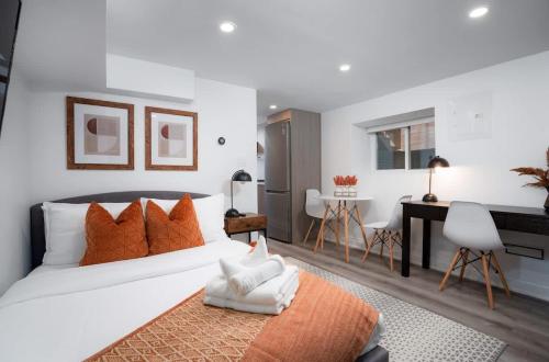a bedroom with a white bed with orange pillows and a desk at Luxury Studio Condo in Downtown Toronto Elm Street in Toronto