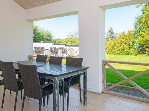 a dining room table and chairs on a patio at 10 person holiday home in Grenaa-By Traum in Grenå