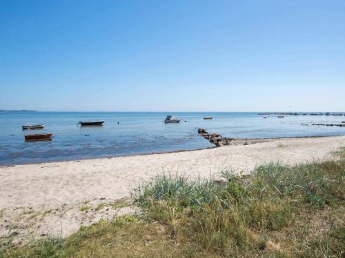 a beach with boats in the water and a group oficans at Luxury Beach House with Spa - By Traum Ferienwohnungen in Sjølund