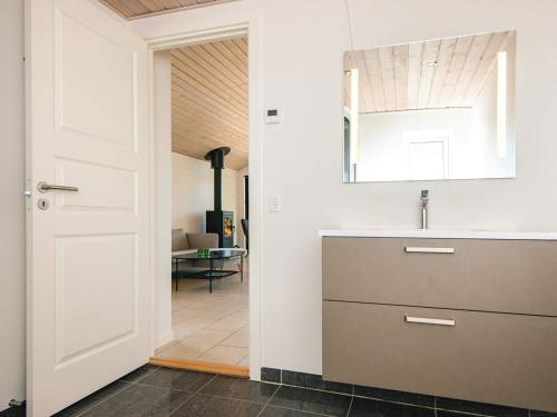 a kitchen with a sink and a mirror and a door at Luxury Beach House with Spa - By Traum Ferienwohnungen in Sjølund