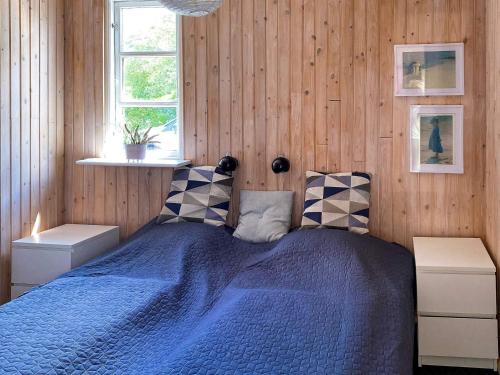 グレーノにある6 person holiday home in Grenaa-By Traumの木製の壁に青いベッドが備わるベッドルーム1室が備わります。