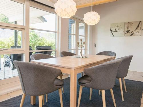 a dining room with a wooden table and chairs at Luxury Beach House with Spa - By Traum Ferienwohnungen in Sjølund