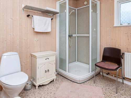 a bathroom with a shower and a toilet and a chair at 6 person holiday home in Thyholm-By Traum in Thyholm