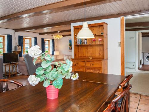 a dining room table with a vase of flowers on it at 14 person holiday home in Ørsted-By Traum in Ørsted