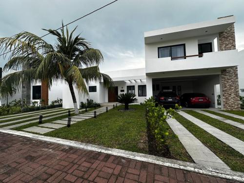 a house with a palm tree in front of it at Casa Fira - Beach House in San José de Guatemala