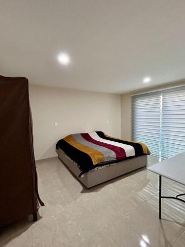 a bedroom with a bed in a room with a window at House near IMSS Trinidad Santa Cruz Tlaxcala in Santa María Atlihuetzián
