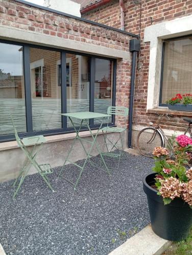 two chairs and a table in front of a building at L' AmbriFany in Quelmes