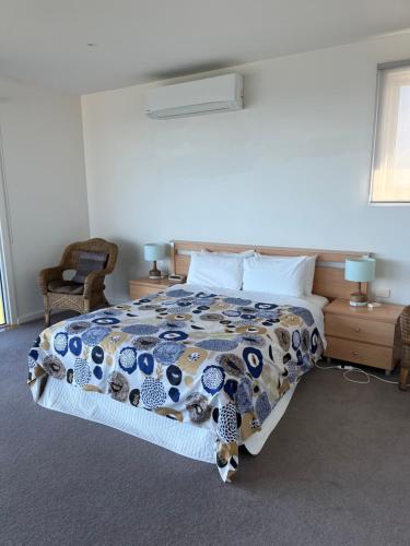 a bedroom with a bed with a comforter on it at Wytonia Penthouse in Port Fairy
