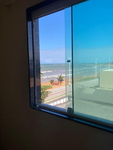 a window with a view of the ocean at San Marino B Rua Pernambuco 26-Estância Monanzitíca in Serra