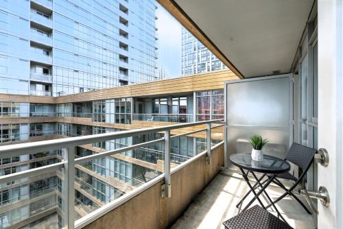 a balcony with a table and chair on a building at Modern Lakefront Escape Walk to Waterfront in Toronto
