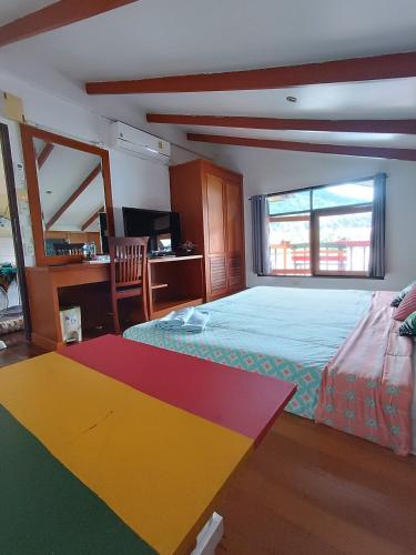 a bedroom with a colorful bed and a desk at Sea House Koh Chang in Ko Chang
