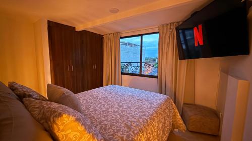 a hotel room with a bed and a window at Casa Bella Apartamentos in Cali