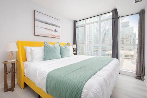 een slaapkamer met een groot bed en een groot raam bij Toronto Getaway 2BR Condo w City Views in Toronto
