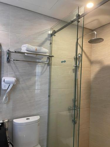 a bathroom with a glass shower with a toilet at Orchids Ocean Hotel in Da Nang