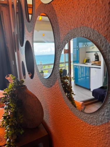 a mirror in a room with a view of the ocean at Dayana Diamond in Le Diamant