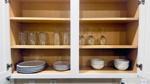 a cabinet filled with plates and bowls and glassware at Self Chk-In 10mins to Ft Cavazos in Killeen