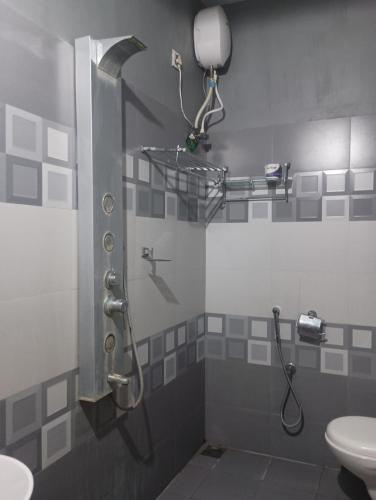 een badkamer met een douche, wastafel en toilet bij Dolphin villa Beach Resort in Alleppey