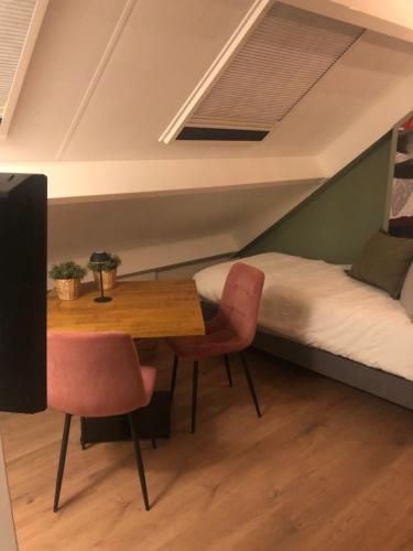 a room with a bed and a table and chairs at B&B Op de Bongerd, de Tiny House beleving! in Winssen