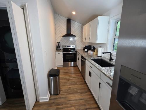 a kitchen with white cabinets and a stove top oven at 2-BR Modern Home for Families & Work in Greenville