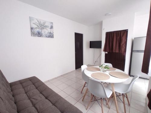 a living room with a couch and a table and chairs at Departamento Luz de Lino in Guadalajara