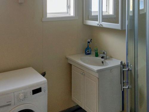 a bathroom with a sink and a washing machine at 7 person holiday home in BREIVIKBOTN 