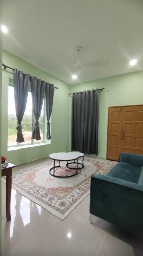 a living room with a blue couch and a table at SBB Homestay in Masjid Tanah