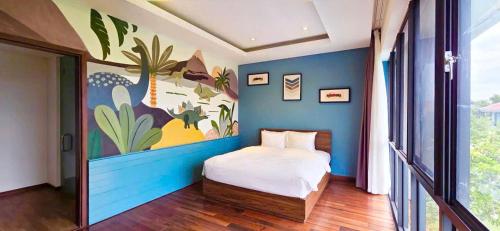 a bedroom with a bed with a blue wall at Danang Villas Complex in Danang