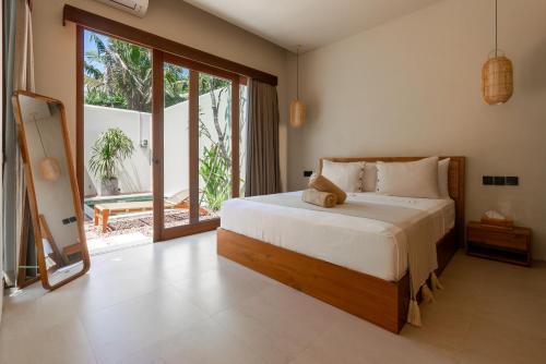 ウルワツにあるCasa Wayan Gede, private pool villa in the heart of Binginの大きなベッドと大きな窓のある寝室