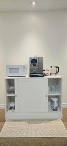 a white shelf with a microwave and a appliance on it at Cozy Basement Suite in Lower Sackville