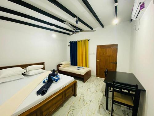 a bedroom with two beds and a desk and a piano at Pigeon Island Beach View Villa - Nilaveli in Nilaveli