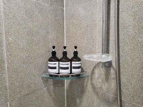 three bottles of wine sitting on a shelf in a shower at #Long-term accommodation inquiries#Suwon Convention Center#Gwanggyo Lake Park#Daily bedding change in Suwon