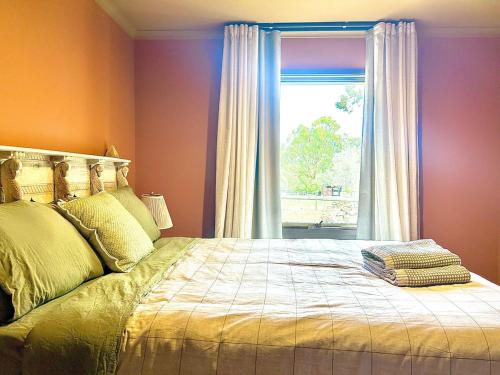 a bedroom with a large bed with a window at Tuscan Farmhouse in Launching Place